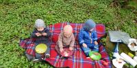 Børn der spiser på tæppe
